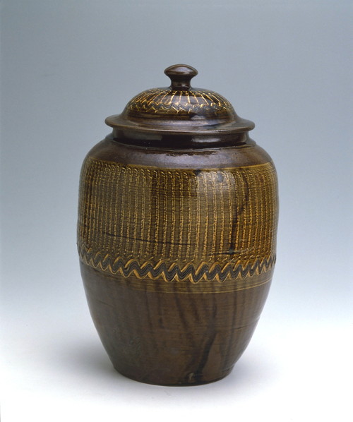 Lidded jar with brush marks design in brown glaze